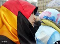 A young Turkish girl wears a headscarf in the colors of the German flag