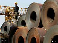 A worker stands on a stack of rolled steel on a dock at Guangzhou, in south China's Guangdong province 