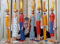 Artista plástico Stefan Hempel coloca o braço em um de seus coelhos de madeira em seu ateliê em Stralsund. Os coelhos da Páscoa de 80 centímetros de altura são algumas das divertidas figuras que Hempel fabrica para a venda em galerias de todo o país