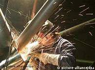 Sparks fly in the dark as a man welds metal sections in the metro train station under Hamburg's airport