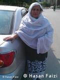 Zahida Kazmi stands next to her taxi in Islamabad