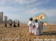 Children with WWF T-shirts stood before a representation of the Earth on the beach in Durban