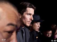 In this photo taken on Monday, Dec. 12, 2011, English actor Christian Bale, center, is led by security guards upon arrival on the red carpet for an event of the Zhang Yimou-directed new movie 