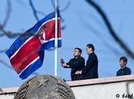 North Korean embassy staff members lower their national flag at half-mast to mourn the death of North Korean leader Kim Jong Il on the roof of the embassy in Beijing, China, Monday, Dec. 19, 2011.  Kim Jong Il, North Korea's mercurial and enigmatic longtime leader, has died of heart failure. He was 69. (AP Photo/Andy Wong)