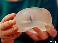 A plastic surgeon holds a silicone gel breast implant made by PIP