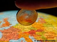 A finger, a euro coin and a map of Europe