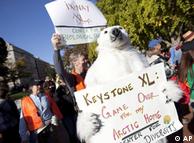 Demonstrators march with a replica of a pipeline during a protest to demand a stop to the Keystone XL 