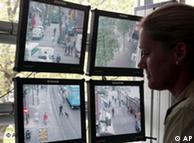 A policewoman looks at video monitors showing street activity