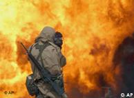 Journalist mit Kamera vor brennendem Ölfeld im Irakkrieg 