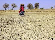 Women in the Indian state of Rajasthan walk over a parched area to get water