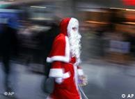 Ein Weihnachtsmann läuft durch die Innenstadt in Düsseldorf. Menschen hasten an ihm vorbei.