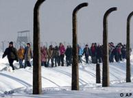 A column of people walking through the grounds of the former Nazi concentration camp at Auschwitz 