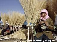 Chinese farmers sell straw brooms at a farmers' market in northwest China