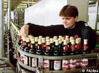 A person inspects bottles on a production line in the Budvar brewery 