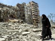 A woman walking through rubble in a suburb of Beirut