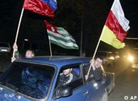 Waving the flags of Russia and the two Georgian breakaway provinces, Abkhazia and South Ossetia, local residents ride a car as they celebrate the independence referendum