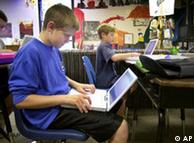 A boy sits with a notebook computer on his lap