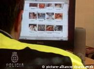 A Spanish police officer looks at confiscated child pornography