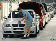 Production line worker cleaning BMW badge. 
