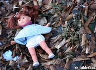 A child's doll lies in the woods
