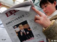 A woman reads a newspaper with a front page photo of Chinese Premier Wen Jiabao reading his work report to the National People's Congress, in Bejing Tuesday March 6, 2007.  Seeking to calm churning social tensions, Wen on Monday opened China's parliament by offering up a list of expensive new programs catering to groups ranging from the military to the rural poor.  The headline highlights one of Wen's proposals - free text books for college students.  (AP Photo/Greg Baker)