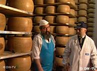 Cheesemaker in front of slabs of parmesan