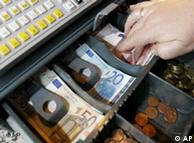Hand reaches into a cash register full of euro notes