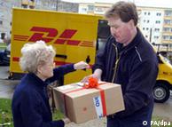 Una señora recibe un paquete de Quelle con el correo