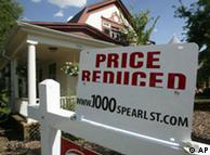A sign to inform prospective buyers that the price has been reduced sits on top of the sale sign outside a single-family home in south Denver