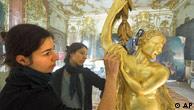 Restorers work on a golden statue in Potsdam's New Palace