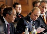 Russia's President Vladimir Putin, center, flanked by Foreign Minister Sergey Lavrov, left, and Russia's Special envoy to the EU Sergei Yaztrzhembsky, right, reads a note passed to him during the EU/Russia summit ar the 18th century  Mafra Palace Friday, Oct. 26 2007, in Mafra, north of Lisbon. (AP Photo/Armando Franca)