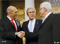 Ehud Olmert and Mahmoud Abbas shake hands as George W. Bush looks on