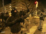 A plainclothes policeman aims his rifle as he patrols in Villiers-le-Bel, a northern Paris suburb