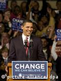 Obama smiles behind a podium with the slogan 
