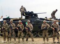 NATo troops stand in front of a tank