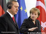 Merkel and Erdogan in front of German, Turkish flags