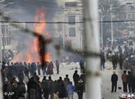 Protesters gather around burning debris in the streets of Lhasa, Tibet