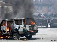 A UN vehicle burns in the street after riots swept through Mitrovica