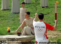 The first bearer, Alexandros Nikolaidis, Olympic winner of Teakwondo, and actress Maria Nafpliotou in the role of the high priestess raise the torch with the Olympic flame during the rehearsal for the lightning ceremony