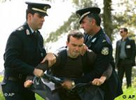 Policemen detain a protester at the beginning of the flame-lighting ceremony