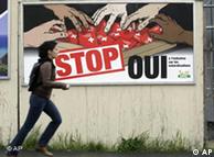 A woman runs past a billboard showing different colored hands reaching for Swiss passports and the word 