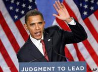 Obama speaks on a podium with one raised hand and the words Judgement to Lead on a sign in front of him