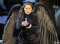 Mihoko Fujimura as Kundry wearing a dark dress with black wings and holding a small flask