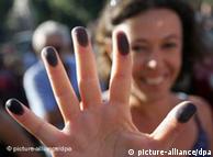 A woman with ink on her fingers protests a proposal to conduct a census of Roma in and near Rome