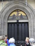 Tourists stand in front of the church door in Wittenberg where Luther is purported to have posted his theses 