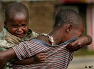 Protegee, carrying her sibling on her back, cries as she looks for her parents through the village of Kiwanja, 90 kms north of Goma, eastern Congo