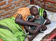 Uma mulher com malária e seu filho esperam por ajuda médica em um hospital do Sudão