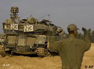 An Israeli soldier in front of a tank