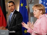 President Barack Obama looks on as German Chancellor Angela Merkel speaks to reporters