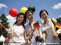 Three Chinese students waving german flags in Berlin
